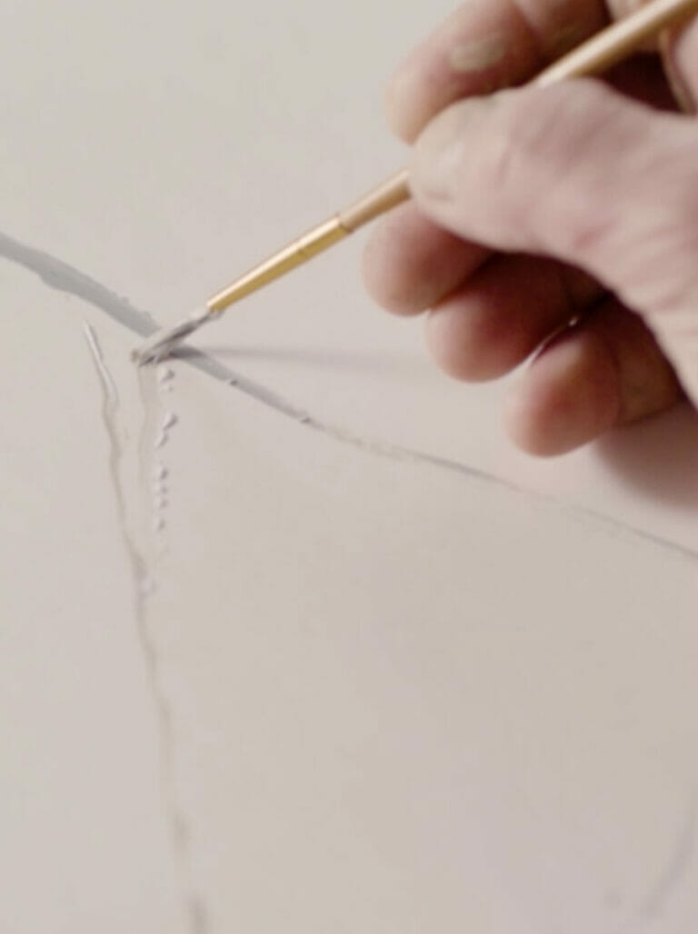 יש מחזיקה מכחול שמצייר עורק על משטח שיש פורצלן של אבן קיסר