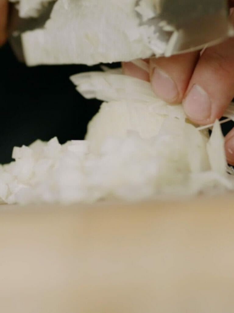 יש מחזיקה סכין קוצצת בצל על משטח שיש פורצלן של אבן קיסר