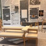 שולחן עץ לבן מעוצב וייחודי על רקע טפט המציג טקסטים כתובים בשחור ולבן