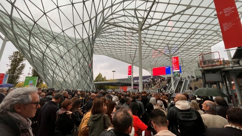 תור ארוך של מאות אנשים מתחת לגג זכוכית ומתכת ביריד העיצוב במילאנו