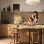 ילדה עומד מחזיקה מצלמה ומצלמת, הילדה עומדת ליד משטח שיש של אבן קיסר מדגם ICON